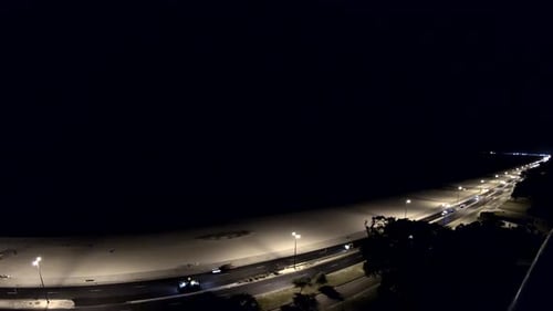 accéléré, le crépuscule se transforme en nuit alors qu'un orage clignote au loin, une équipe de travail travaille sur la route principale