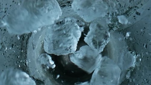 Ice Cubes Falling Blender Closeup. Grinding Iced Pieces in Container Top View