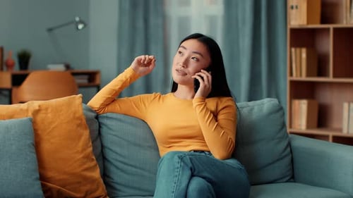 Smiling Woman Talking on Phone While Sitting on Couch