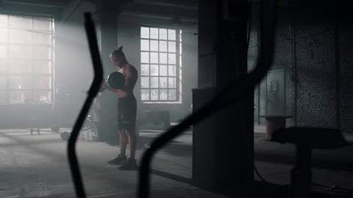 Athletic Man Working Out with Dumbbells in Gym