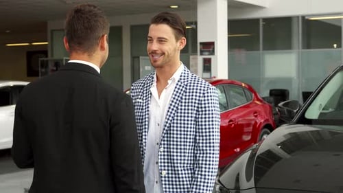Two Men Discuss Cars at the Car Dealership