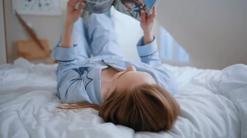 Lying Woman Reading Book in Bed at Morning Apartment Closeup Girl Resting Home