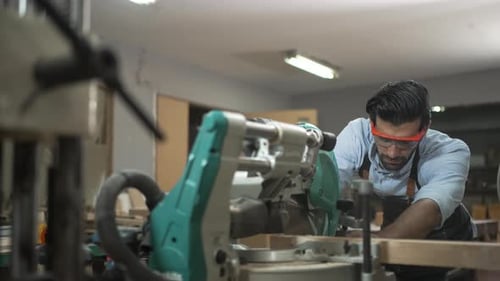 Carpenter is working together at workshop.