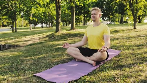 Man Meditating Outdoors on Yoga Mat in Park