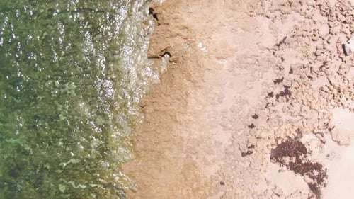 90 degree above drone shot of tropical waters with rocky edges