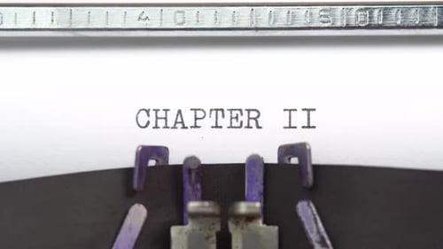 Chapter two phrase closeup being typing and centered on a sheet of paper on old vintage typewriter