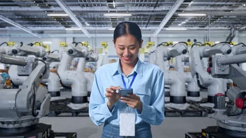 Woman Smiling, Using Phone Among Robotic Arms