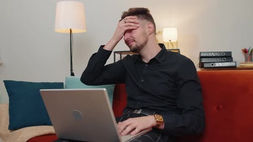 Frustrated Man Working on Laptop at Home
