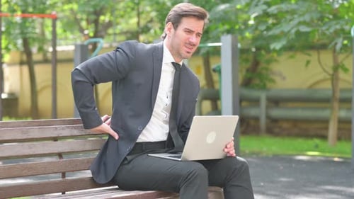 Man in Suit Using Laptop Has Back Pain