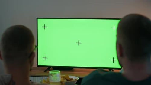 Male Friends Watching Green Screen TV in Apartment