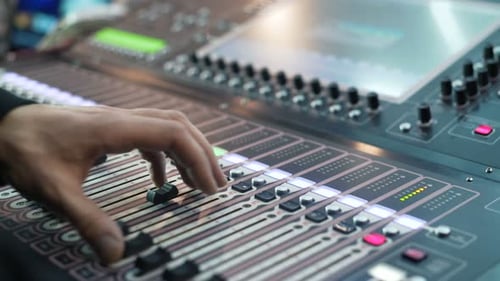 Hands of Audio Engineer Working on a Professional Analog Console, Moving Faders,