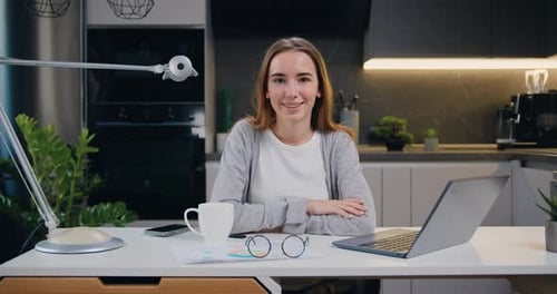 Smiling Woman at Desk in Modern Kitchen