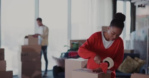 Young Couple Packs Cardboard Boxes for Moving