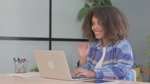 Woman Video Conferencing on Laptop in Office Setting