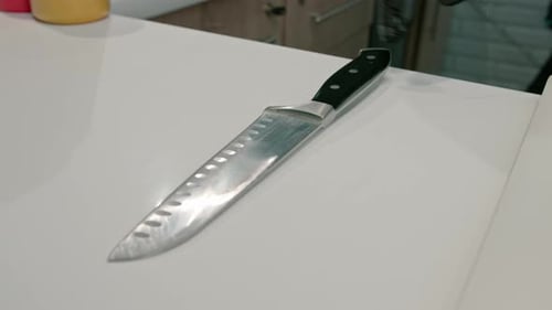 Close-up of a sushi maker in gloves cutting a mushroom on a white board in a professional kitchen