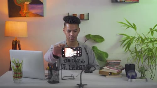 Young influencer blogger recording a scene for his follower with his modern smartphone for sharing o