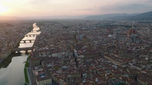 Backwards Fly Above Historic City Centre at Sunset