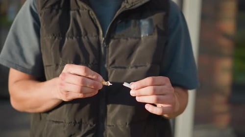 Mains cassant une cigarette à l'extérieur par une journée ensoleillée