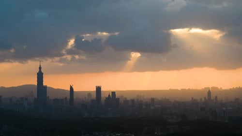 At dusk, the sun breaks through the clouds and shines on Taipei City.