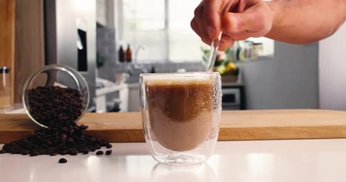 Iced Coffee Drink Being Mixed with Straw Indoors