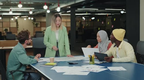 Diverse Team Collaborating on Project in Modern Office