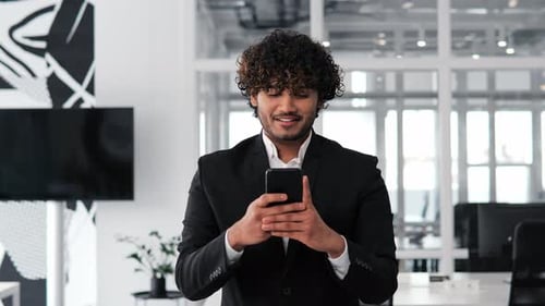 Striking Man Indian Businessman Typing a Message on His Mobile Phone in Office