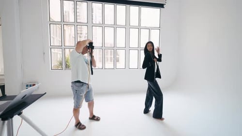 Photographer Taking Pictures of Model Posing in Studio