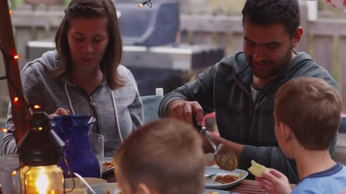 Family enjoys outdoor meal together on patio