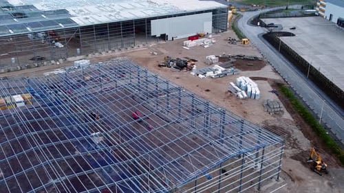 Montage inachevé d'une charpente en acier de chantier de construction d'un bâtiment industriel, vue aérienne