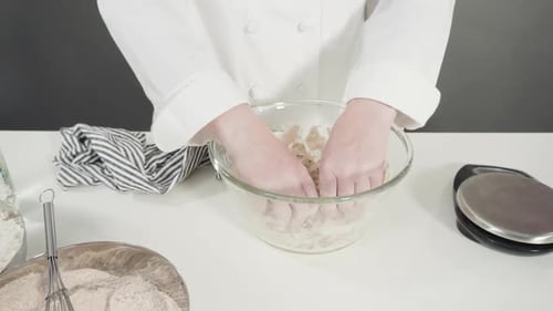 Hands Mixing Dough in Bowl on Table