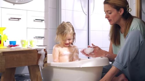 Little Girl Enjoys Bath Time with Her Mother
