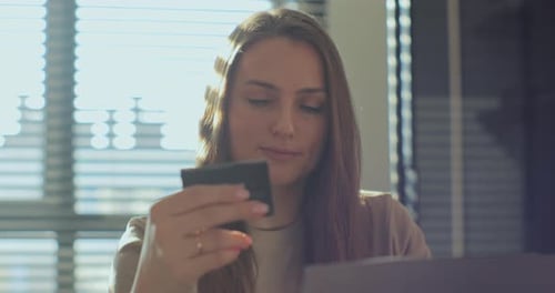 Woman with Long Hair Looks at Memory Card