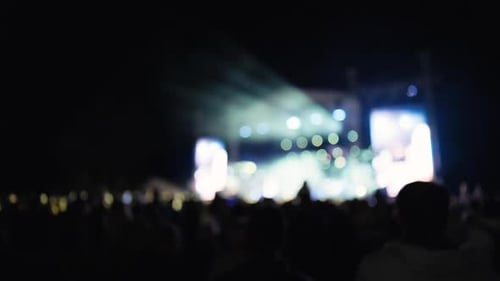 Eine aufregende Nachtkonzertszene mit einem großen Publikum und schillernden Bühnenlichtern für ein unvergessliches Erlebnis