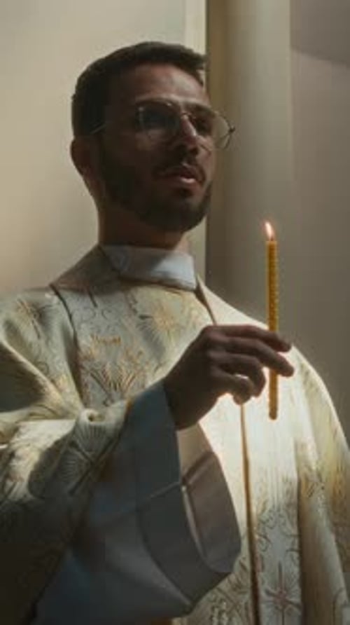 Man Holding Candle in Religious Setting
