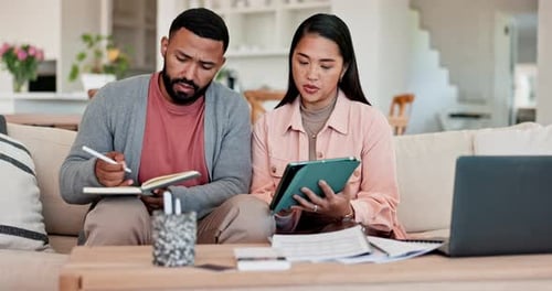 Couple Works Together at Home with Tablet and Notebook