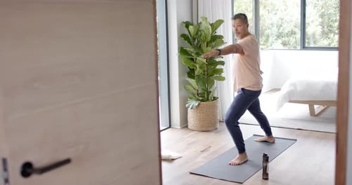Mature Man Practicing Yoga in Bedroom