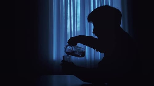 Silhouette of Person Pouring Water in Quiet Room
