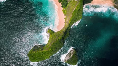 Unusual rocky cliff on pristine sandy shore with azure ocean waves. Nusa Penida, Kelingking beach in