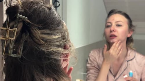 Woman Applying Acne Cream in Mirror Skincare Routine