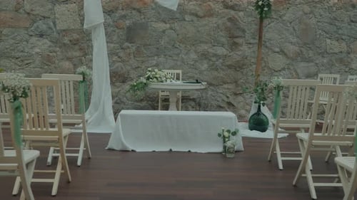 Empty Wedding Venue Setup with Stone Wall Backdrop