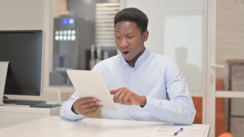 African Businessman with Loss on Tablet in Office