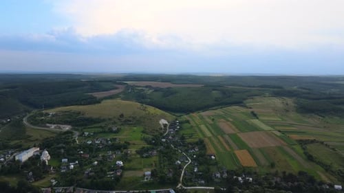 Aerial Landscape View of Village Houses and Distant Green Cultivated Agricultural Fields with