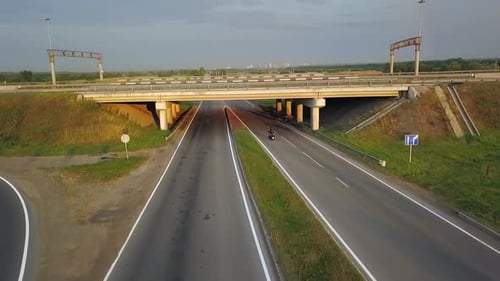 Aerial View of Motorcycle Driving on Highway Overpass Clip