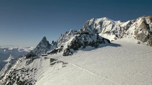 Teleférico de alta montaña con monte blanco y antena aérea de grupo de alpinistas