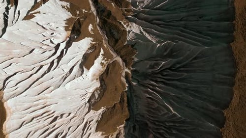 Luftbild einer breiten Schlucht mit felsigen Klippen von beiden Seiten des kleinen Canyons: Klippsteinhänge und gelb