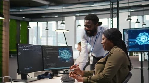 Happy Engineers Enjoying Funny Conversation at Desk While Using AI