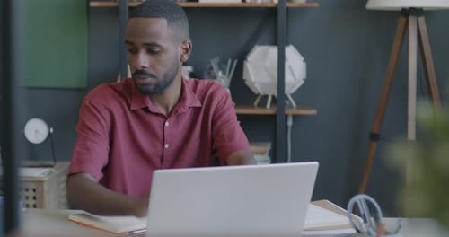 Successful Entrepreneur Working with Laptop Typing and Drinking Tea Indoors at Desk in Office