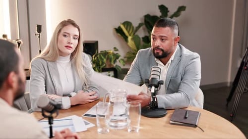 Man and Woman Recording a Podcast at Table
