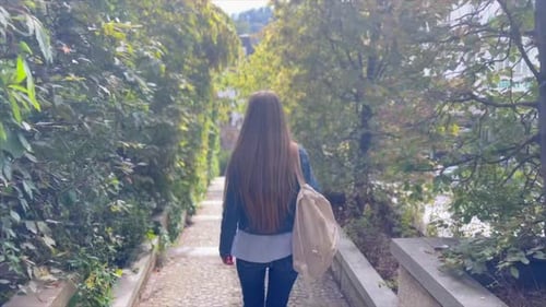 Woman Walking Down Park Stairs with Backpack