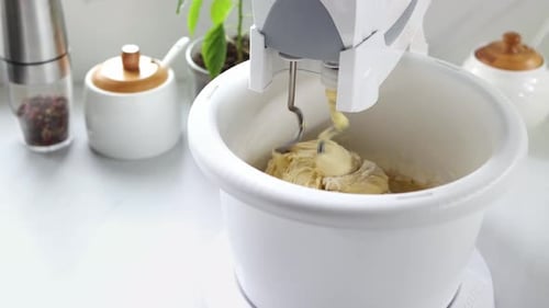 Mixer stirs the dough in a spinning bowl. A stationary mixer with a bowl kneads the dough